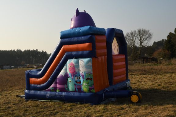 Aufblasbare Rutsche mit bunten Seiten, in einem Feld aufgestellt.